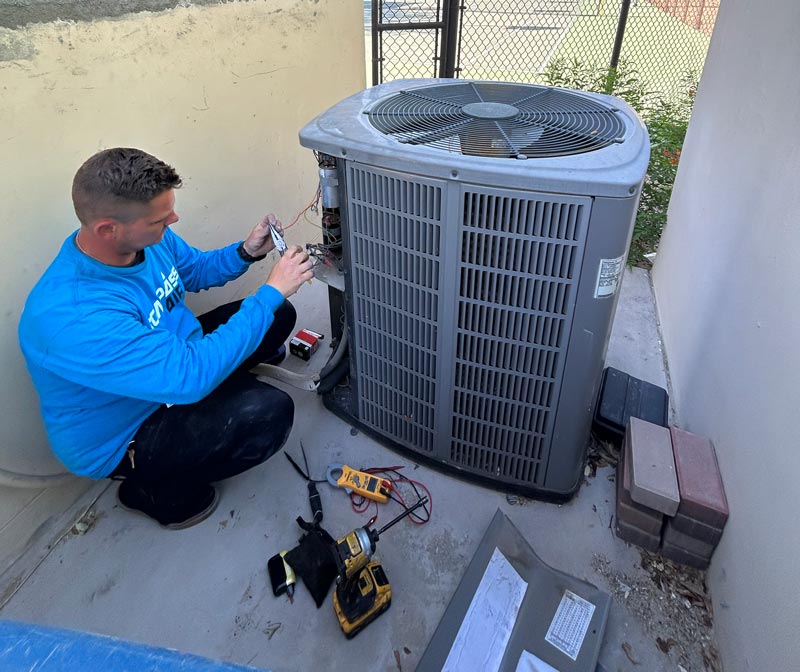 Technician diagnosing an air conditioner during AC repair in Chandler, AZ